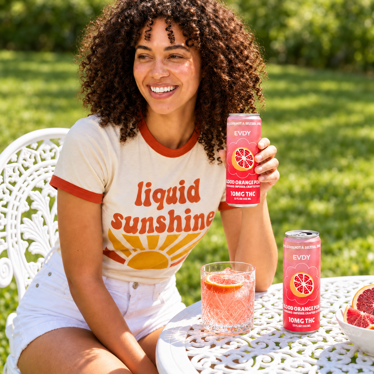 EVDY Blood Orange POM can in a sunny backyard lifestyle scene